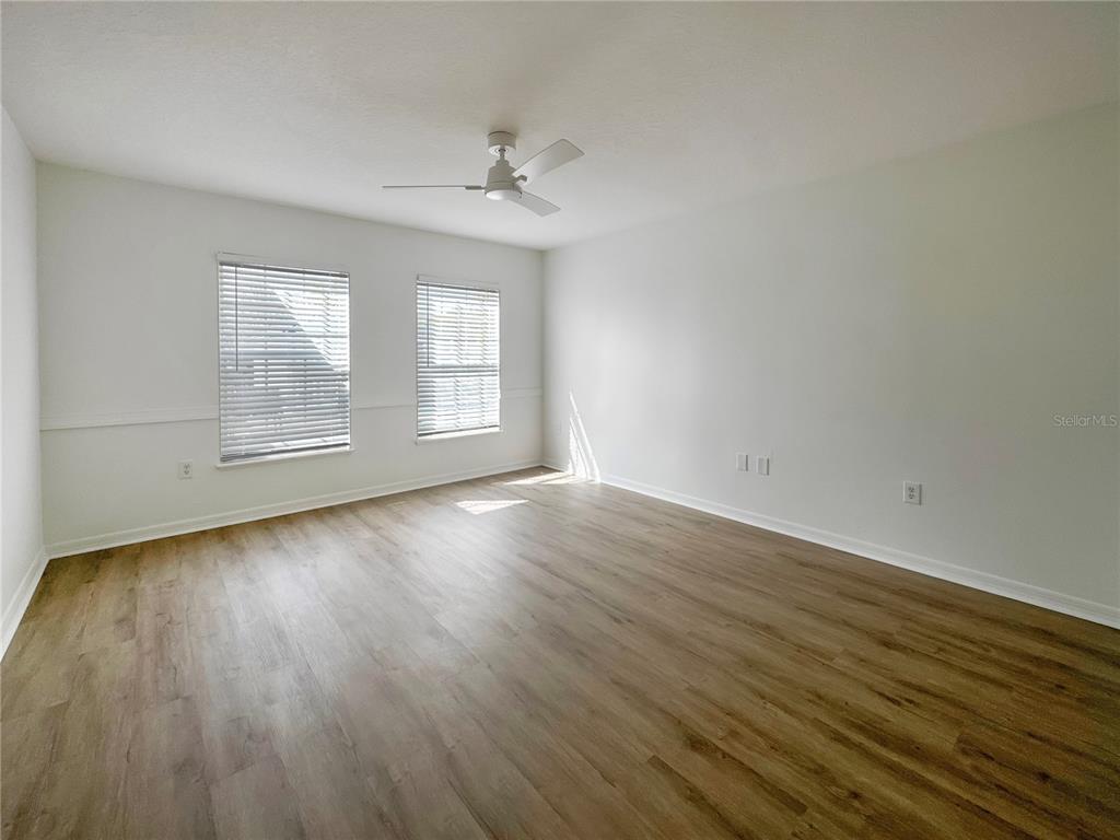 2109 Aitkin Loop Leesburg, FL 34748 - Photo 23 of 33 an empty room with wooden floor and windows