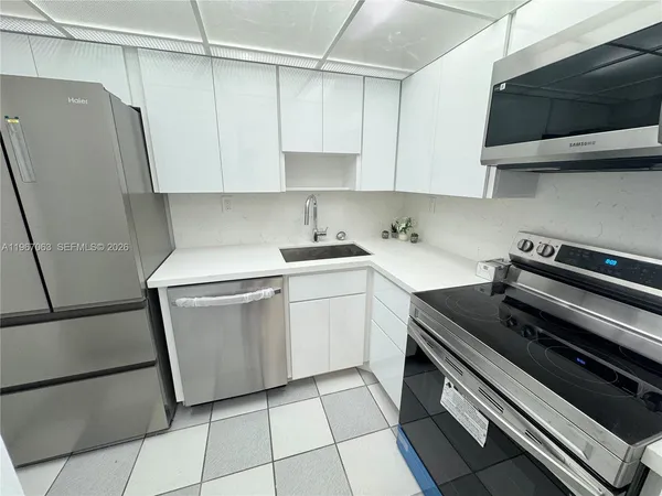 a kitchen with stainless steel appliances a refrigerator sink and cabinets