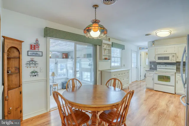 a dining room with furniture wooden floor a rug and a painting