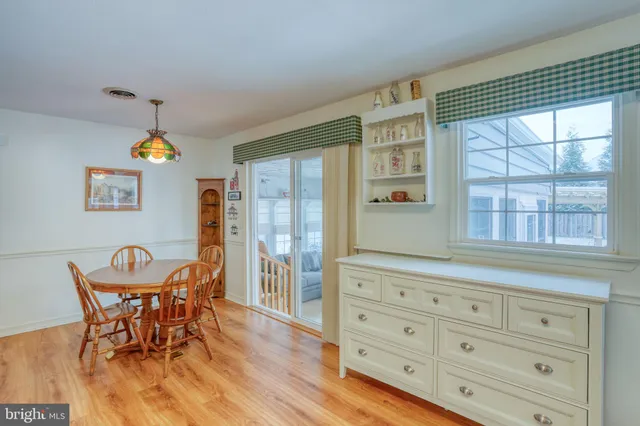 a view of a dining room with furniture a chandelier and wooden floor