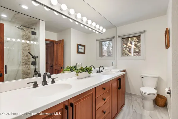 a bathroom with a sink double vanity granite and a toilet