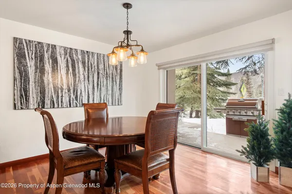 a dining room with furniture a chandelier and wooden floor