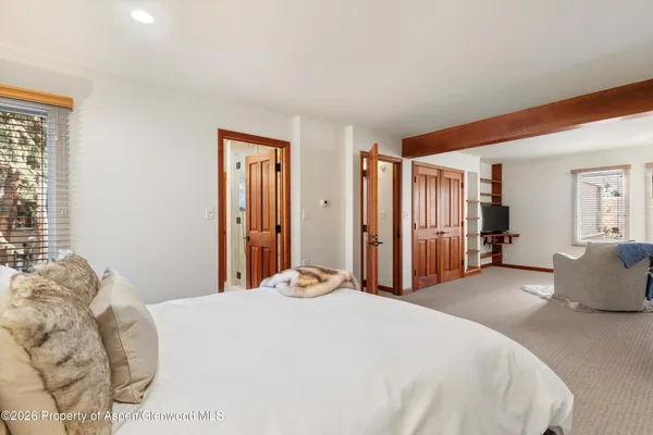 a bedroom with a large bed and wooden floor