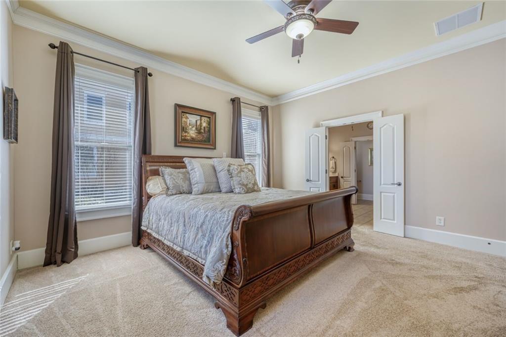 2380 Muskogee Lane Braselton, GA 30517 - Photo 20 of 30 a spacious bedroom with a bed and a chandelier