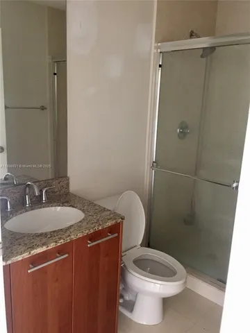 a bathroom with a granite countertop sink toilet and a mirror