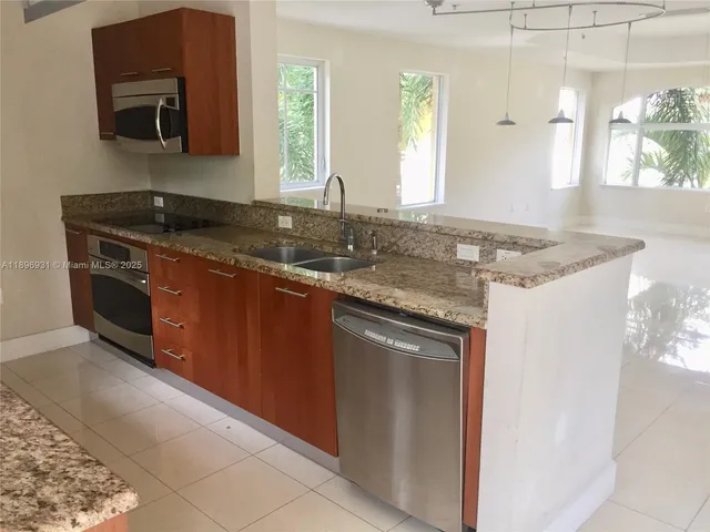 a kitchen with stainless steel appliances granite countertop a sink stove and microwave
