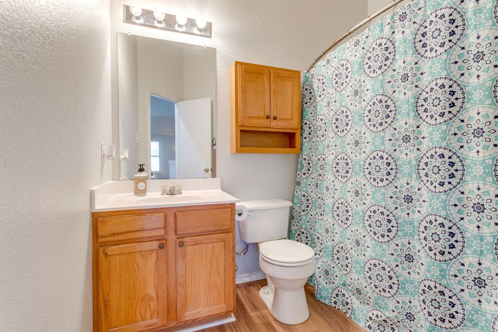 4816 Sleepy Ridge Circle Fort Worth, TX 76133 - Photo 26 of 36 Full bathroom with vanity, a textured wall, a shower with shower curtain, and light wood-style flooring