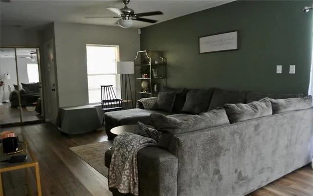 a living room with furniture and a ceiling fan