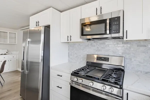 a kitchen with stainless steel appliances granite countertop a stove microwave and refrigerator