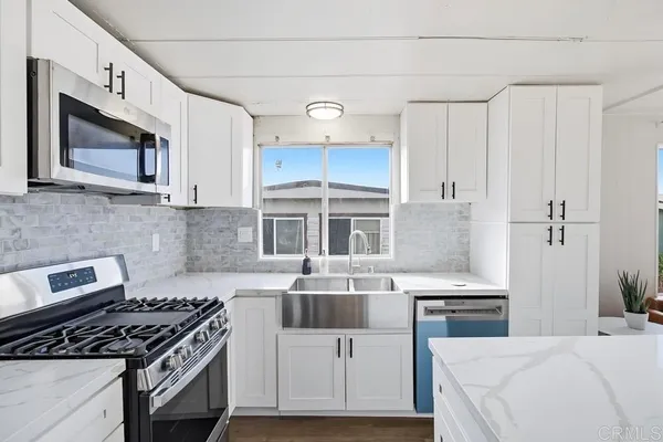 a kitchen with cabinets stainless steel appliances and a counter space
