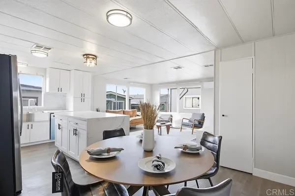 a open dining room with stainless steel appliances a table and chairs