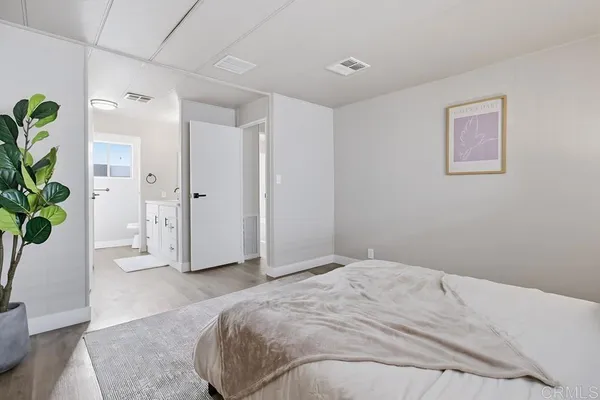 a spacious bedroom with a bed and a potted plant