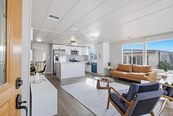 a living room with furniture and kitchen view