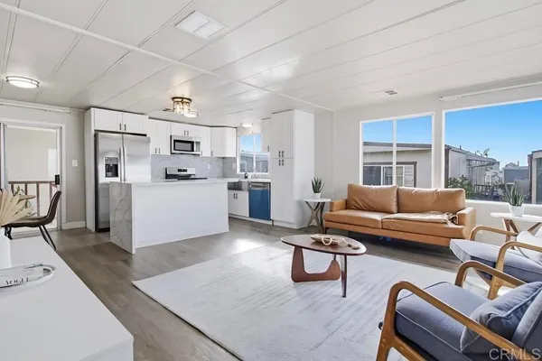 a living room with furniture and kitchen view