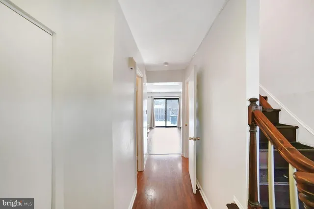 a view of a hallway with wooden floor and staircase