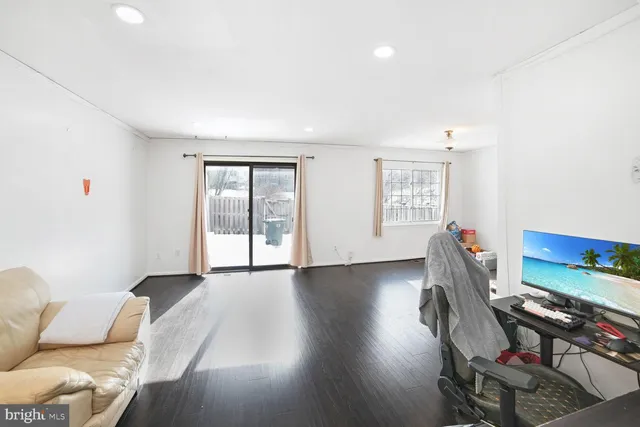 a furnished livingroom with windows and wooden floor