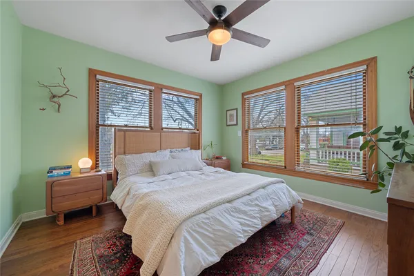 a bedroom with a bed dresser and a large window