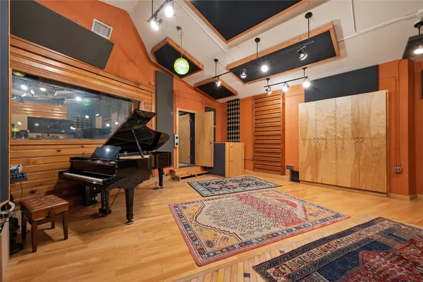 a living room with furniture a air conditioner and wooden floor