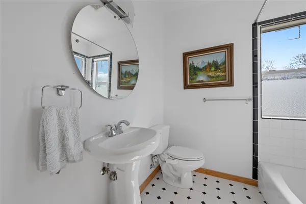a bathroom with a sink mirror and a toilet