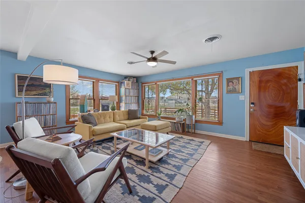 a living room with furniture a table and wooden floor