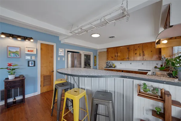 a kitchen with stainless steel appliances granite countertop a refrigerator a stove and a wooden floors