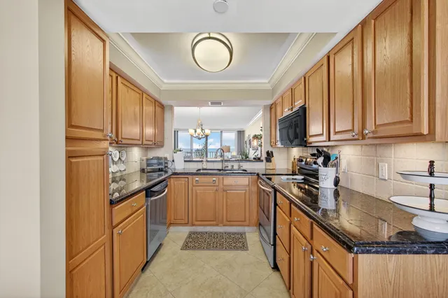 a kitchen with stainless steel appliances granite countertop a stove a sink dishwasher and a refrigerator