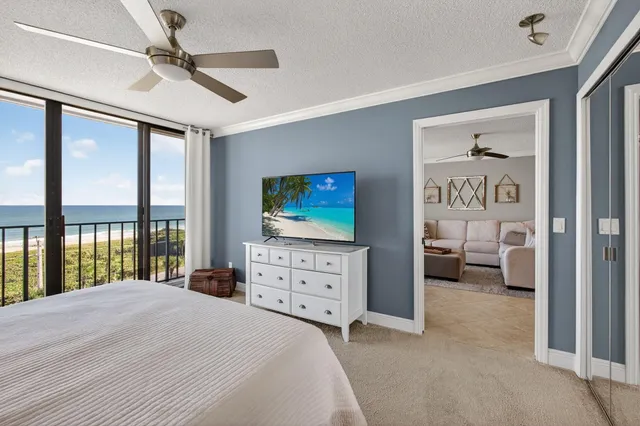 a bedroom with a bed and a flat tv screen on dresser