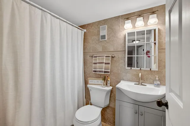 a bathroom with a sink a toilet and shower curtain
