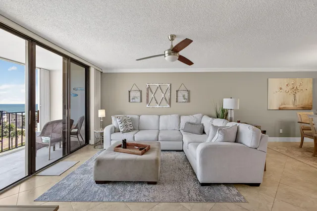 a living room with furniture and a floor to ceiling window