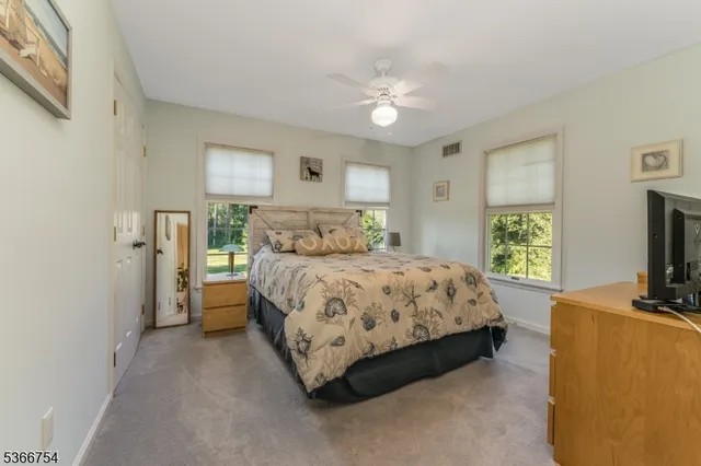 a bedroom with a bed flat screen tv and window
