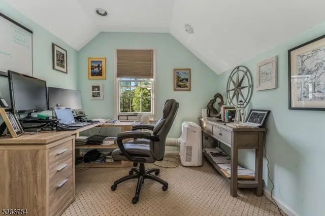 a view of a workspace with furniture and a window