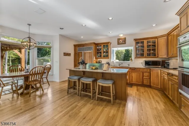 a kitchen with stainless steel appliances wooden floor dining table and chairs