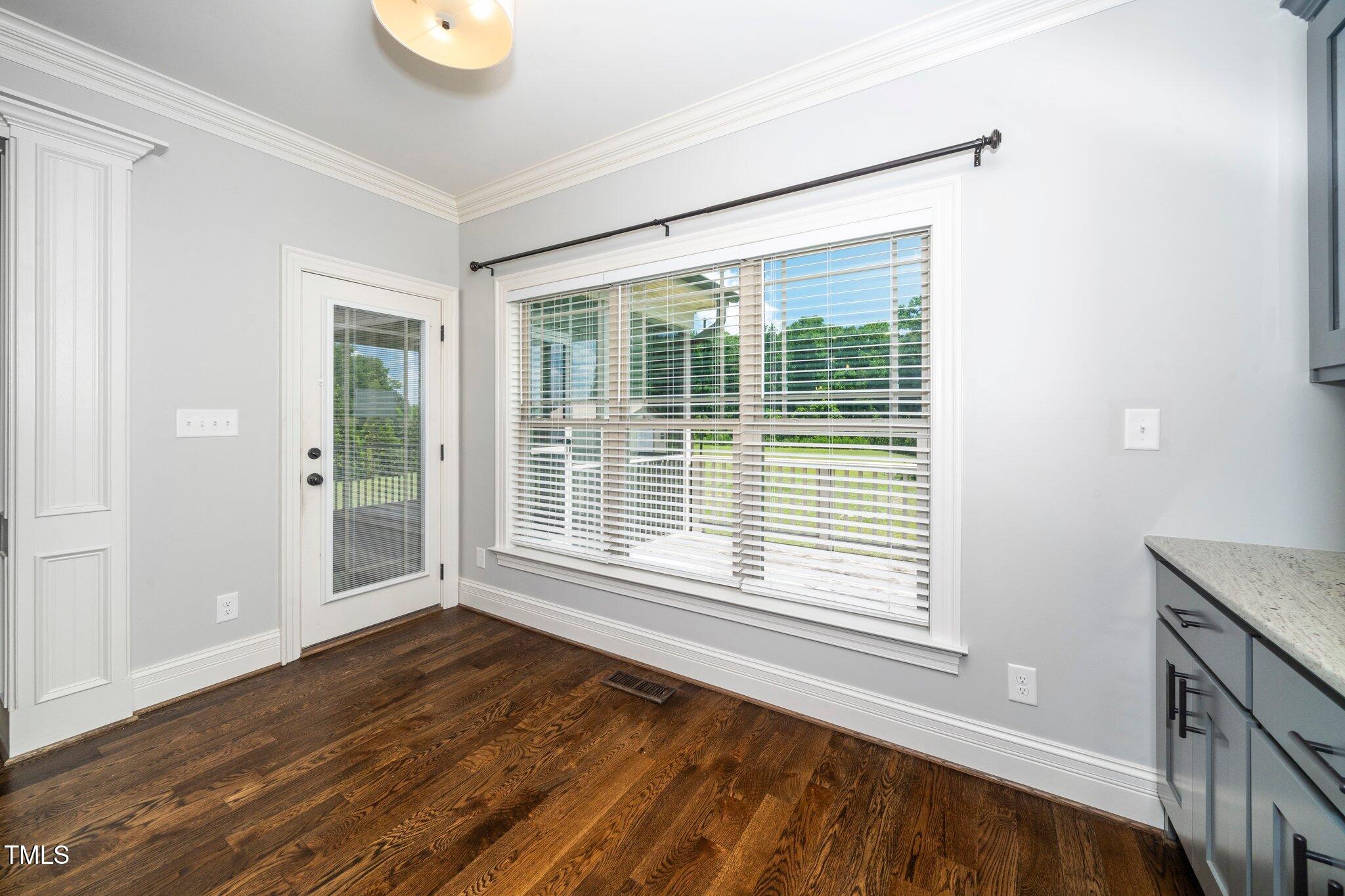 6737 Dwight Rowland Road Willow Spring, NC 27592 - Photo 16 of 50 a view of an empty room with wooden floor and a window