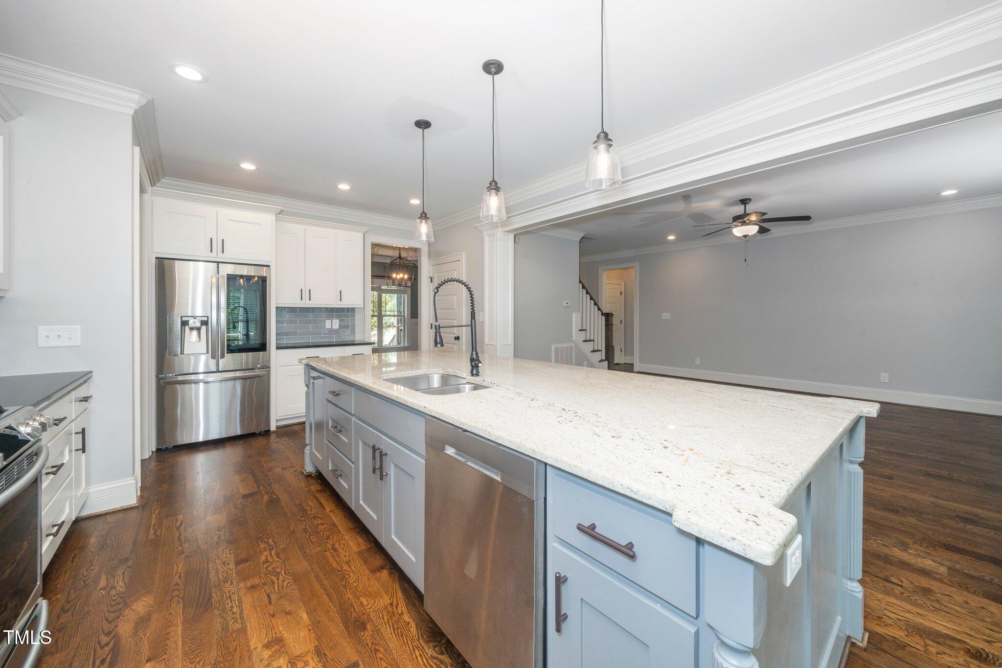 6737 Dwight Rowland Road Willow Spring, NC 27592 - Photo 17 of 50 a kitchen with a sink stainless steel appliances and white cabinets