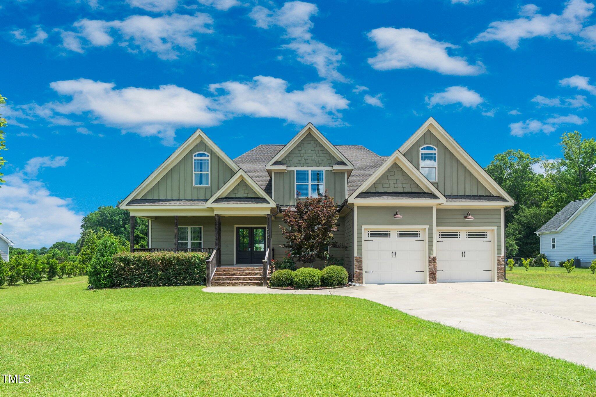 6737 Dwight Rowland Road Willow Spring, NC 27592 - Photo 2 of 50 a front view of a house with a garden and yard
