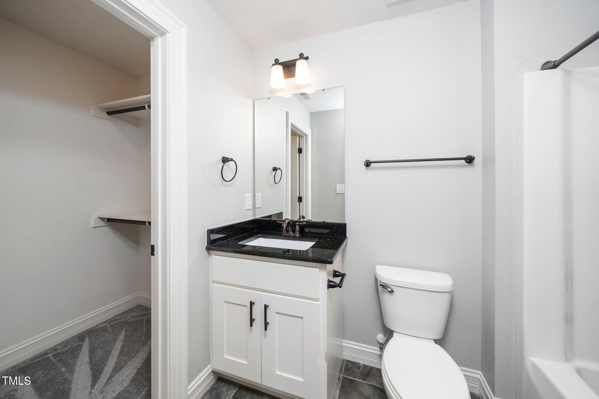 6737 Dwight Rowland Road Willow Spring, NC 27592 - Photo 33 of 50 a bathroom with a granite countertop toilet sink and mirror