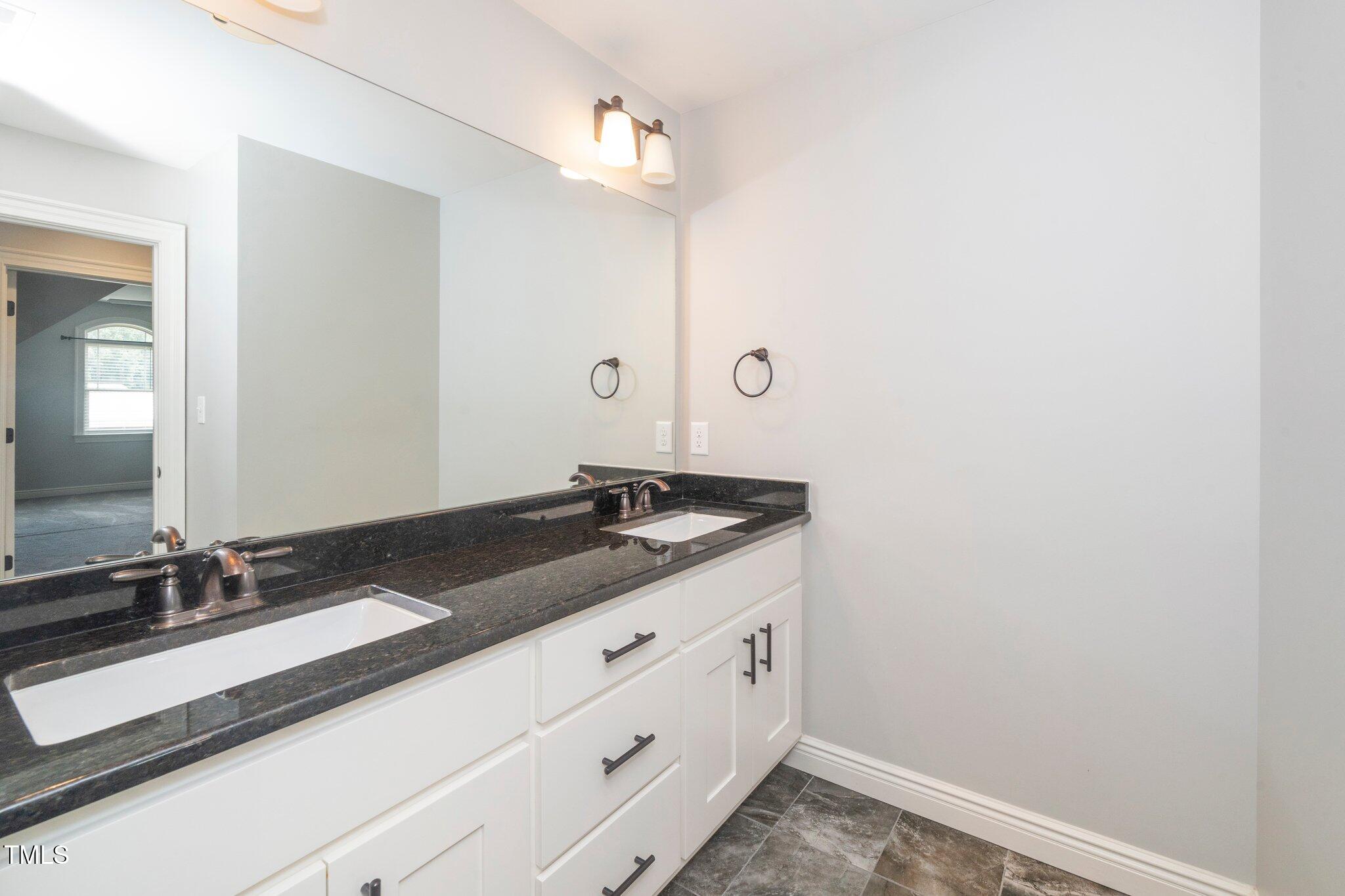 6737 Dwight Rowland Road Willow Spring, NC 27592 - Photo 40 of 50 a bathroom with a sink and a mirror