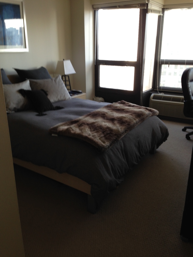 30 East Huron Street, Unit 3901 Chicago, IL 60611 - Photo 7 of 13 a bedroom with a bed next to a window
