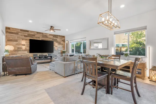 a dining room with furniture a kitchen and chandelier