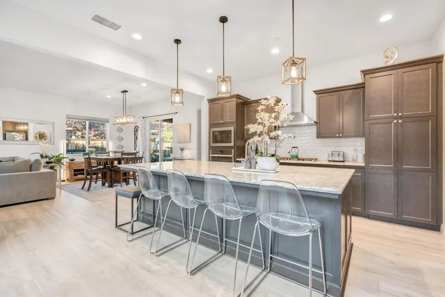 a kitchen with stainless steel appliances granite countertop a sink refrigerator and cabinets