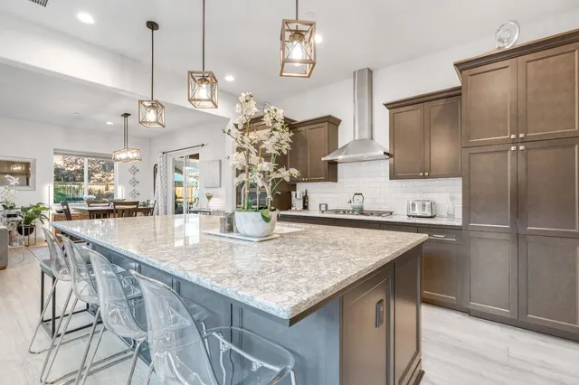 a kitchen with counter top space a sink appliances and a large window
