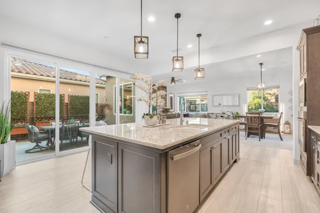 a kitchen with stainless steel appliances granite countertop a sink a stove and a wooden cabinets