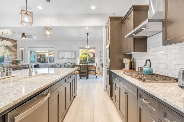 a kitchen with stainless steel appliances granite countertop a sink stove and refrigerator