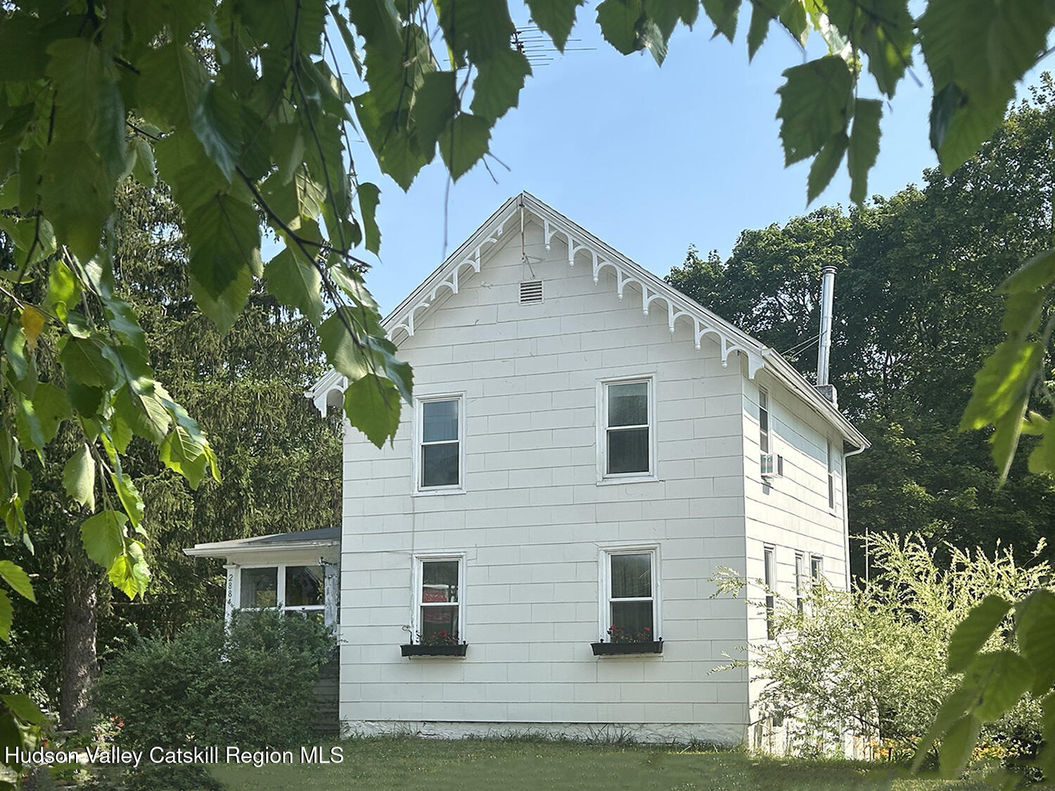 a view of house with a yard and a tree