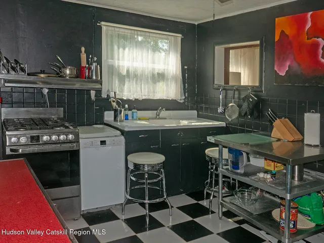 a kitchen with stainless steel appliances granite countertop a sink a stove a dining table and chairs