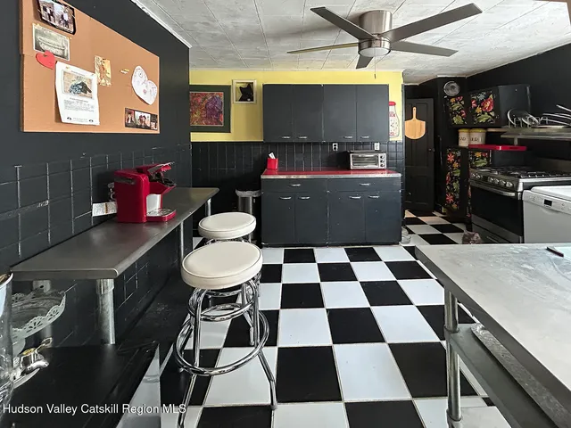 a room with a black white checkered floor with a gaming machine and dining table