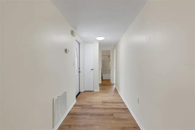 a view of a hallway with wooden floor