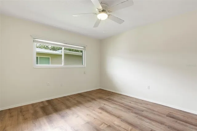an empty room with a window and a fan