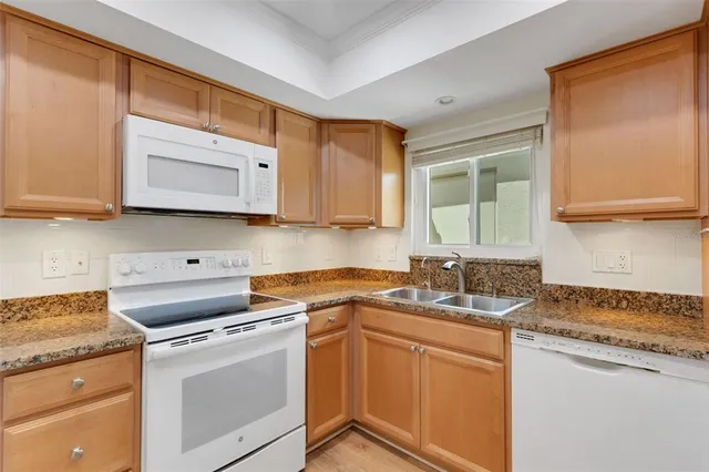 a kitchen with granite countertop cabinets stainless steel appliances and a sink