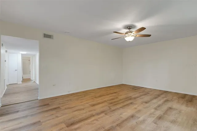 a view of empty room with wooden floor